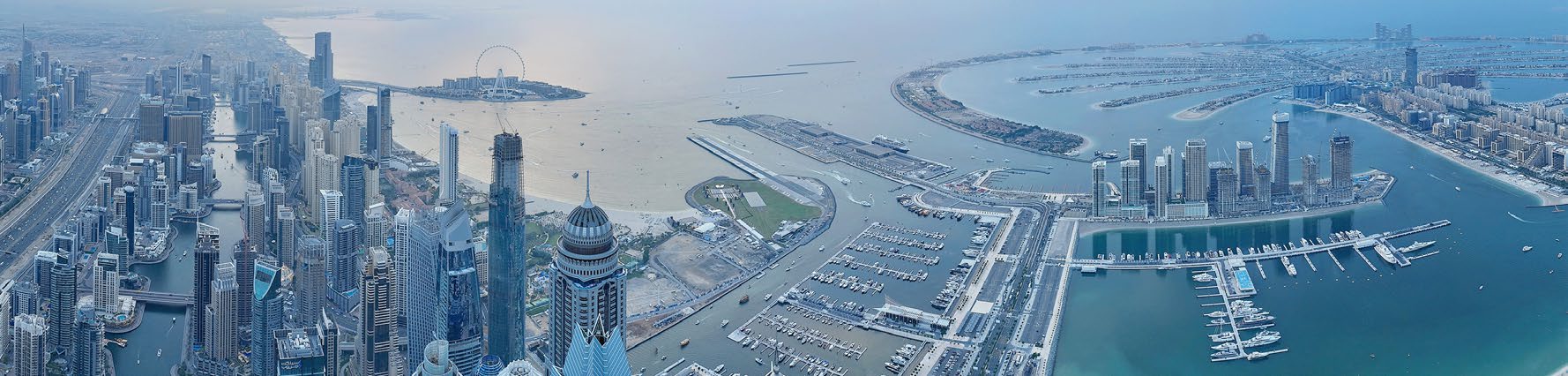 Aerial panorama of Dubai Marina, Dubai Harbour, Ain Dubai and the Palm
